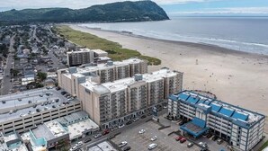 Un hotel sulla costa con diversi edifici, un parcheggio e una spiaggia sullo sfondo.