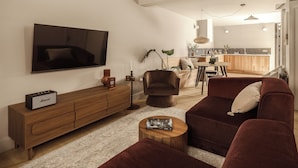 Un saló amb televisió, sofà, taula de centre i un armari de fusta.