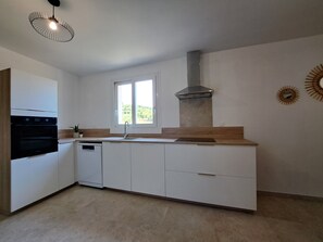 A modern kitchen with white cabinetry, a stainless steel range hood, a window, and a pendant light. - ☆☆☆Spacious New 3-Bedroom Apartment Less Than a 5-Minute Drive from the Beaches ☆☆☆ (San-Nicolao)