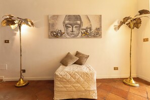 Ein Zimmer mit einem Bett, zwei Stehlampen und einem Buddha-Gemälde an der Wand.