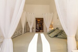 A bedroom with a bed, white curtains, a headboard, and a lamp. - Campo dei Fiori Silver Apartment (Roma)