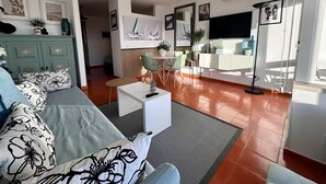 Een moderne woonkamer met een bank, salontafel en eethoek.
