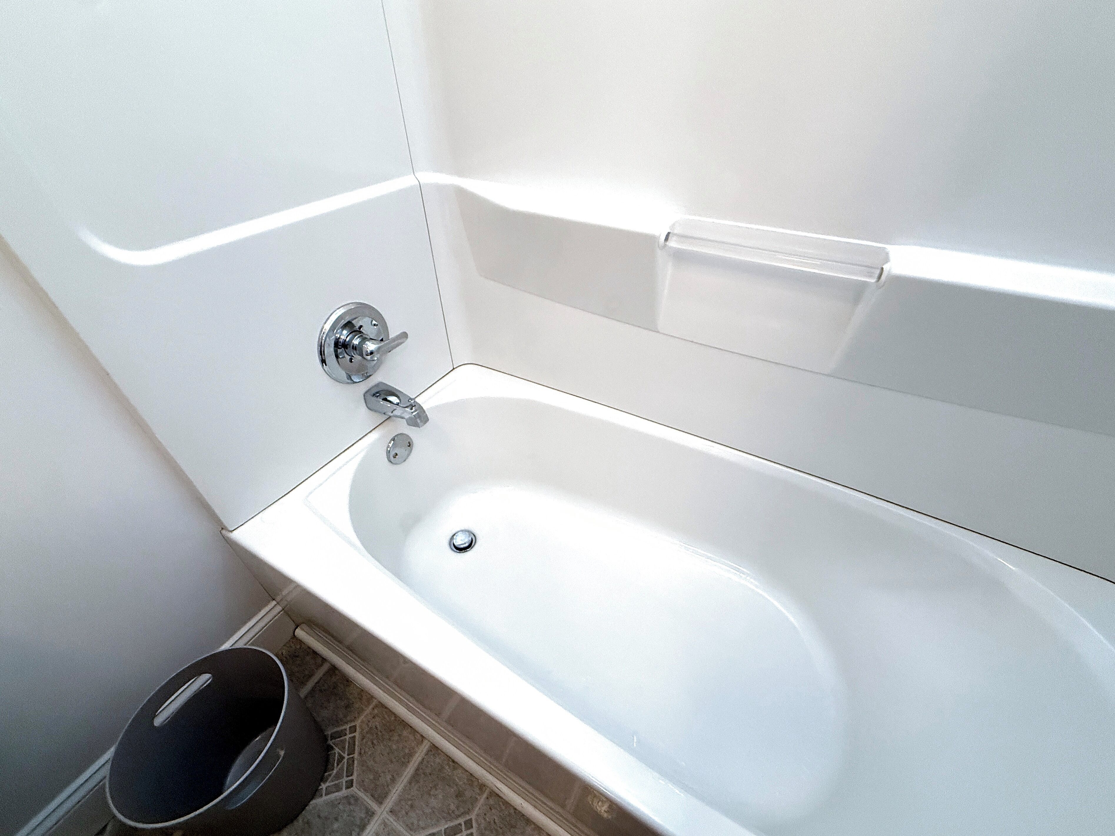 A white bathtub with a chrome faucet and a single lever handle.