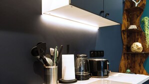 A kitchen with a stove, coffee maker, and utensils on the counter. - Les Grèves, Village Center, 80 meters from the beach (Saint-Jacut-de-la-Mer)