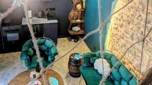 A cozy living room with a green sofa, a wooden coffee table, and a decorative shelf. - Les Grèves, Village Center, 80 meters from the beach (Saint-Jacut-de-la-Mer)