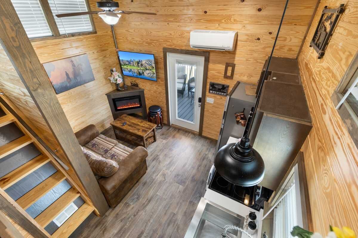 Ein gemütlicher Wohnraum mit Kamin, Fernseher und Holzvertäfelung.