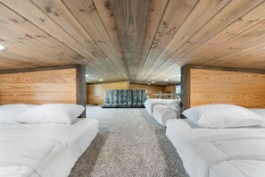 A cabin interior with a loft bed, a cushioned bench, and a wooden ceiling. - Evans Ranch | Rooftop Deck Views (Fredericksburg)