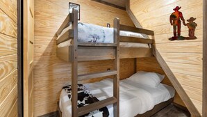 A bunk bed room with wooden walls and a welcome sign. - Tiny Home 140 - Evans Ranch (Fredericksburg)