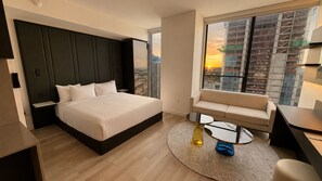 A modern hotel room with a large bed, a sofa, a desk, and a view of the cityscape through the window. - E2611 - West-View Studio with Pool and Gym in Downtown Miami (Miami)