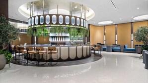 Ein moderner Barbereich mit kreisförmigem Design, Sitzgelegenheiten und einer zentralen Bar.