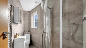 A modern bathroom with a shower, toilet, and sink. - Cozy and Lovely Studio - Close to everything! (London)