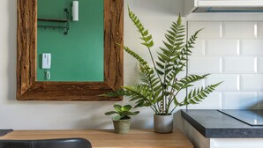 A wooden desk with a potted plant and a mirror with a telephone. - Cozy and Lovely Studio - Close to everything! (London)