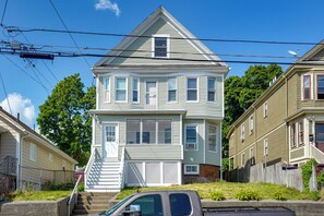A two-story house with a front porch, a staircase, and a garage. - 5 Mi to Boston & Airport! Townhome w/ Skyline View (Everett)