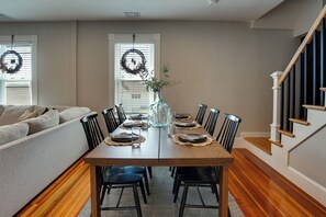 A dining area with a wooden table, black chairs, and a vase with flowers. - 5 Mi to Boston & Airport! Townhome w/ Skyline View (Everett)