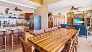 A spacious kitchen with a central island, wooden cabinets, and a large refrigerator. - Beachfront Penthouse with Panoramic Ocean Views (Playa Potrero)