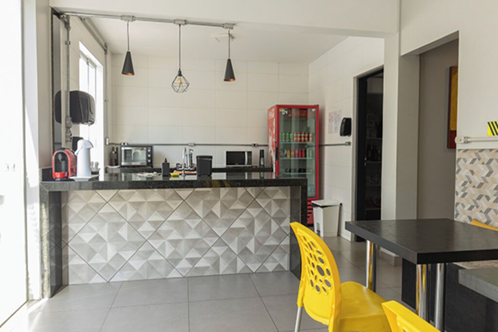 Una cocina moderna con una isla central, microondas y refrigerador rojo para bebidas.