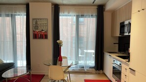 En moderne lejlighed med spiseplads, køkken og store vinduer.