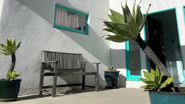 A white building with a curved architectural feature, a bench, and potted plants. - Beautiful Spanish Style house in Silver Lake With Garden (Los Angeles)