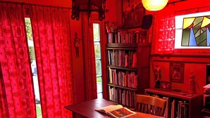 A room with a table, chairs, a bookshelf, a hanging light fixture, and a window with curtains. - Beautiful Spanish Style house in Silver Lake With Garden (Los Angeles)