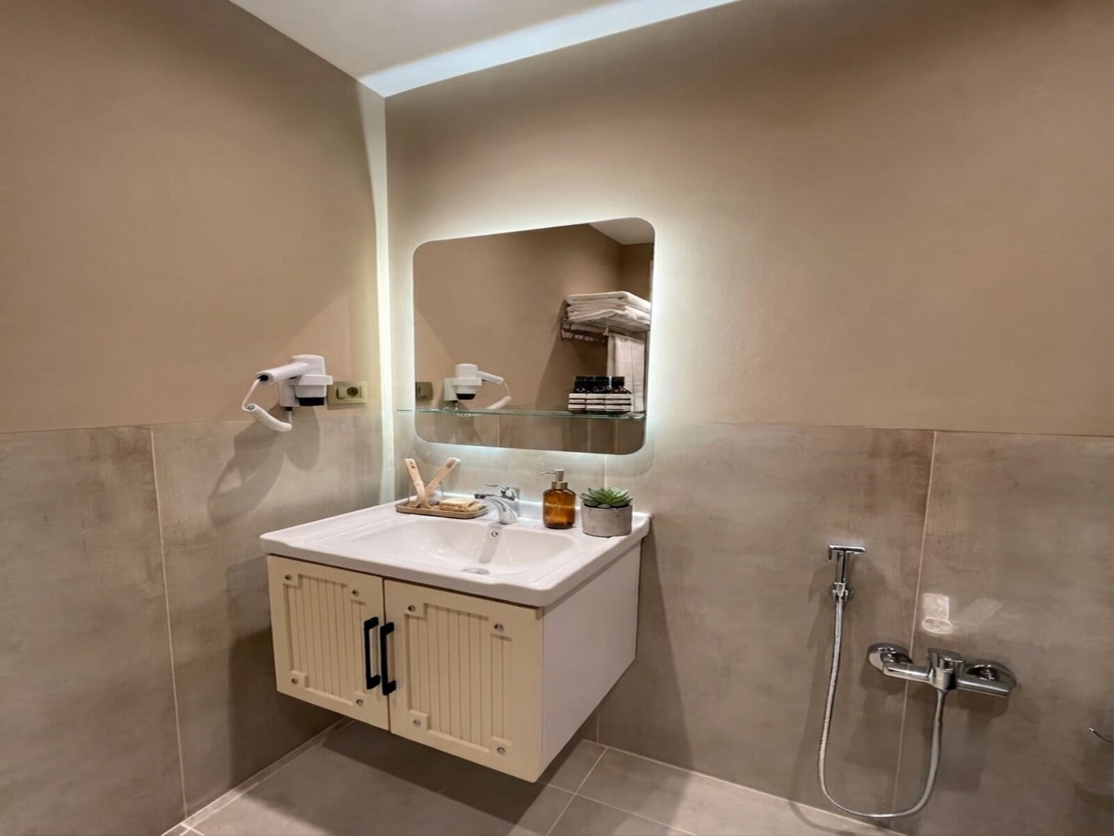 A bathroom with a white sink, a mirror, a towel rack, and a shower.
