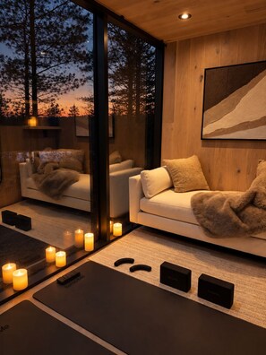 A modern interior with a sofa, candles, and a yoga mat.