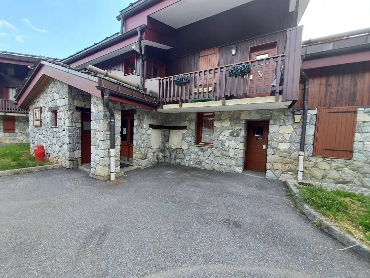 A two-story building with stone walls and a balcony.