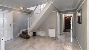 Ein geräumiger Flur mit Treppe, Heizkörper und einer Chandelier.