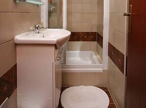 A small bathroom with a sink, a bathtub, and a toilet. - Comfort One Bedroom Apartment with Terrace and Sea View (Pag)