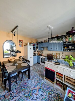 A compact kitchen with a dining area, a refrigerator, a stove, and a microwave. - Artist's house · Terrace · Fécamp · Sleeps 4 (Fécamp)