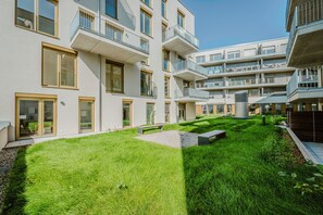 A modern apartment building with multiple balconies, a well-maintained lawn, and a clear sky. - EXQUIS 3 Room Serviced Apartment (Böblingen)