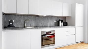 Suite Deluxe, balcón, vistas a la ciudad | Cocina privada | Frigorífico, microondas en la zona común, horno y placa de cocina