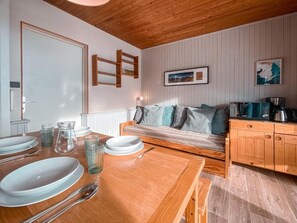 A wooden dining table set with plates, glasses, and cutlery. A wooden bench with cushions is against the wall. - 50m from ski slopes, Ground floor, balcony, tv, ski locker, 30m², Tignes (Tignes)