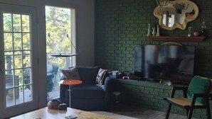 Uma sala de estar moderna com um sofá, televisão e uma mesa de centro.