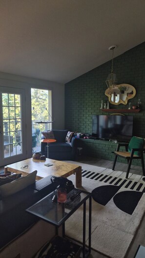 Ein modernes Wohnzimmer mit Sofa, Fernseher und Couchtisch.