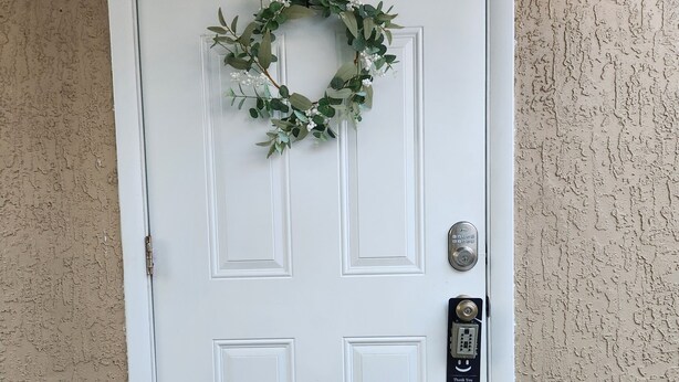 A white door with a surveillance warning sign, a keypad lock, and a doormat. - Cozy and comfy Apt. in the heart of Miami - 1-bedroom/1-bathroom with AC (Coral Gables)