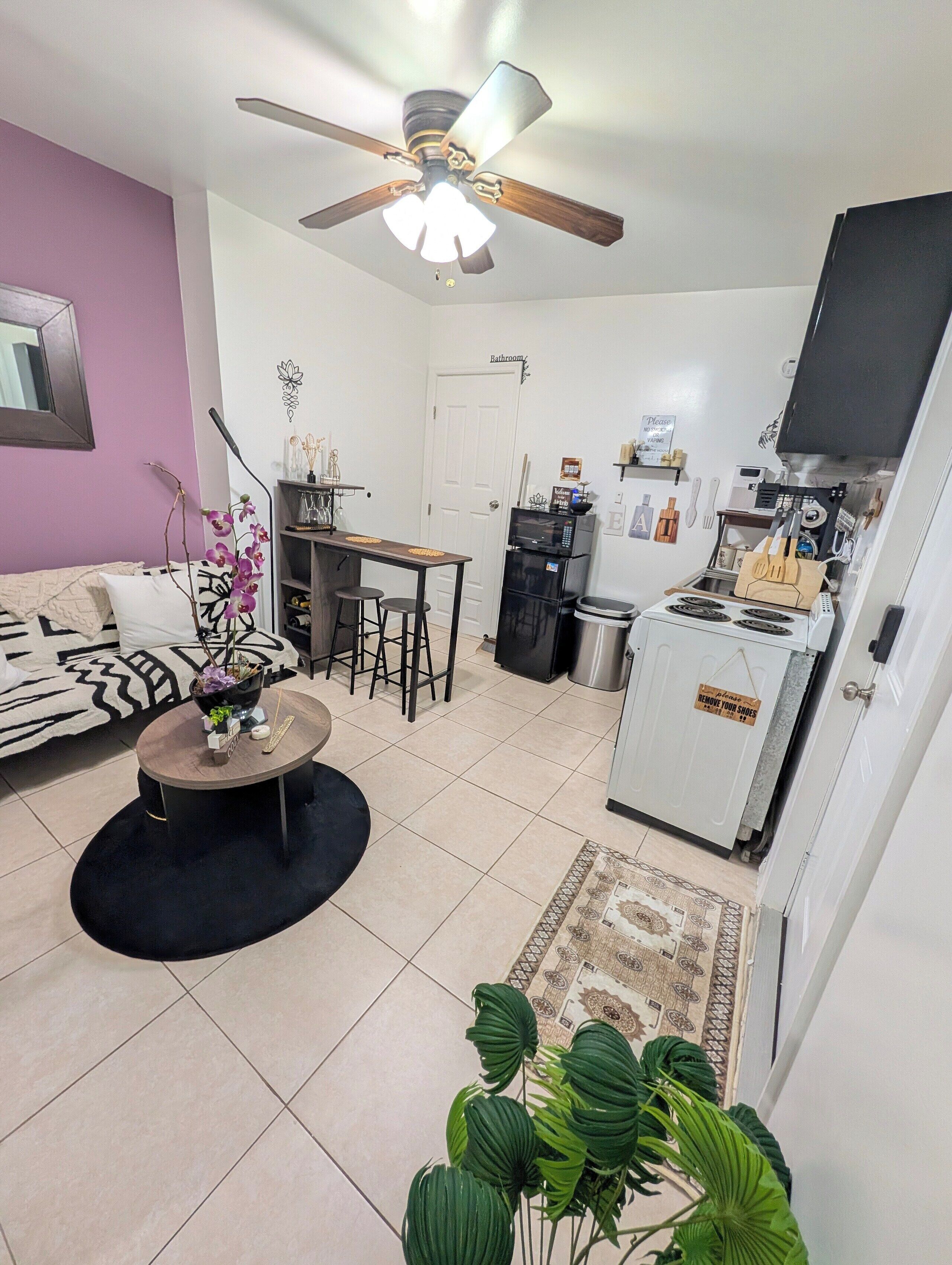 A compact living space with a kitchenette, a dining area, and a seating area with a sofa and coffee table.