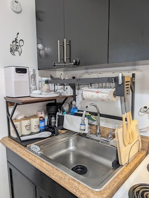 A kitchen with a stainless steel sink, a coffee maker, and a hanging rack above the sink. - Cozy and comfy Apt. in the heart of Miami - 1-bedroom/1-bathroom with AC (Coral Gables)