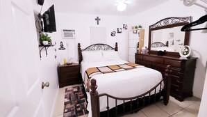A bedroom with a bed, bedside tables, a dresser, a mirror, and a wall-mounted TV. - Cozy and comfy Apt. in the heart of Miami - 1-bedroom/1-bathroom with AC (Coral Gables)