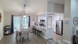 A modern kitchen with white cabinets, stainless steel appliances, and a large island. - Pelican Paradise, Piers, Pints, & Perfect Putts!  (Murrells Inlet)