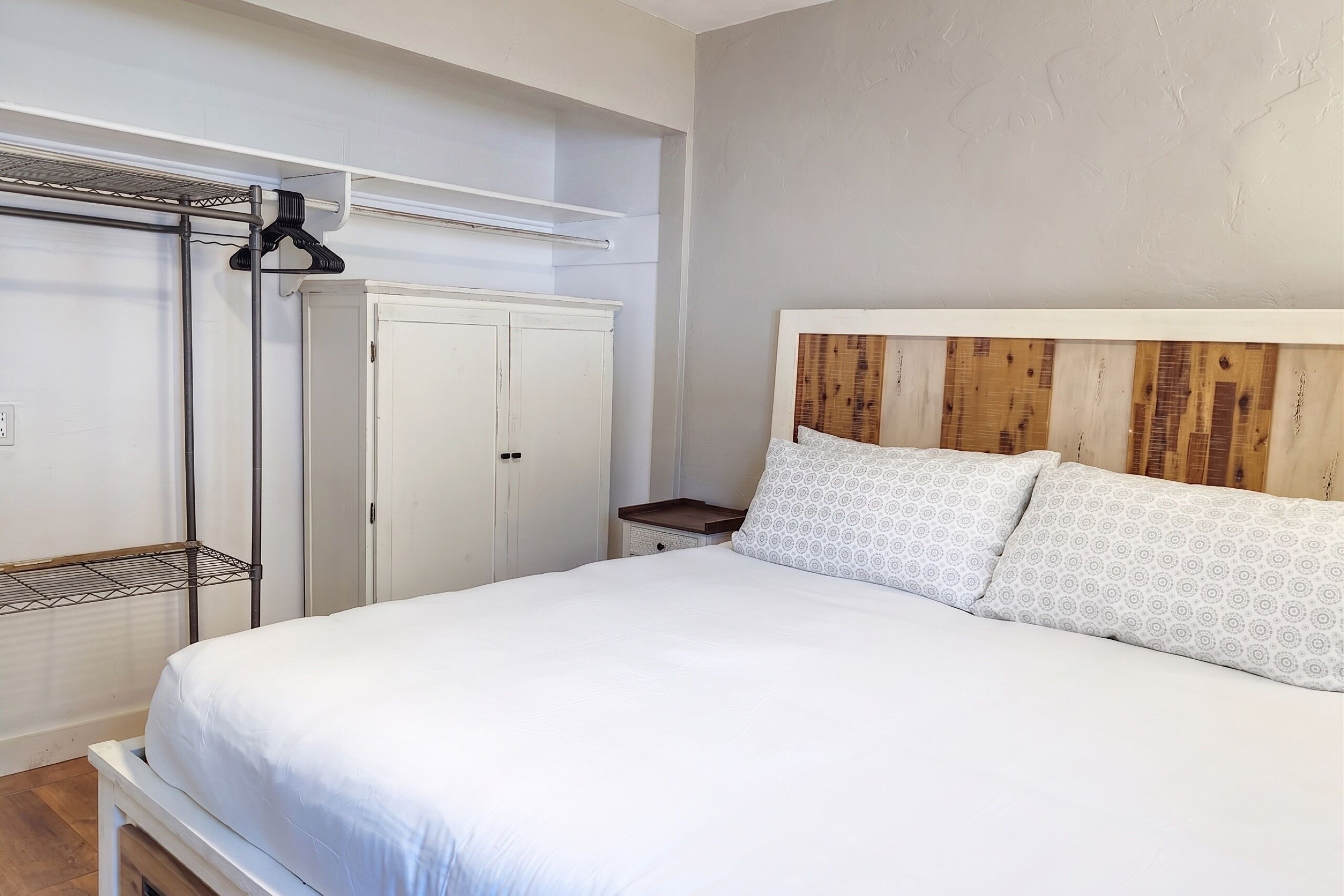 Ein Schlafzimmer mit einem Bett, einem Kleiderschrank und einem Nachttisch.