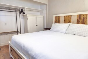 Un dormitorio con cama, armario y estantería.
