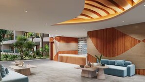 A modern lobby with a reception desk, seating area, and a view of the outdoor garden. - The Surfin Turtle | Luxury Oceanfront Condo at the WAVE in Encuentro (Cabarete)