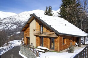 A wooden chalet with a balcony, set against a snowy mountain backdrop. - Chalet, 40m from ski slopes, terrace, tv, 140m², Les 2 Alpes (Mont-de-Lans)