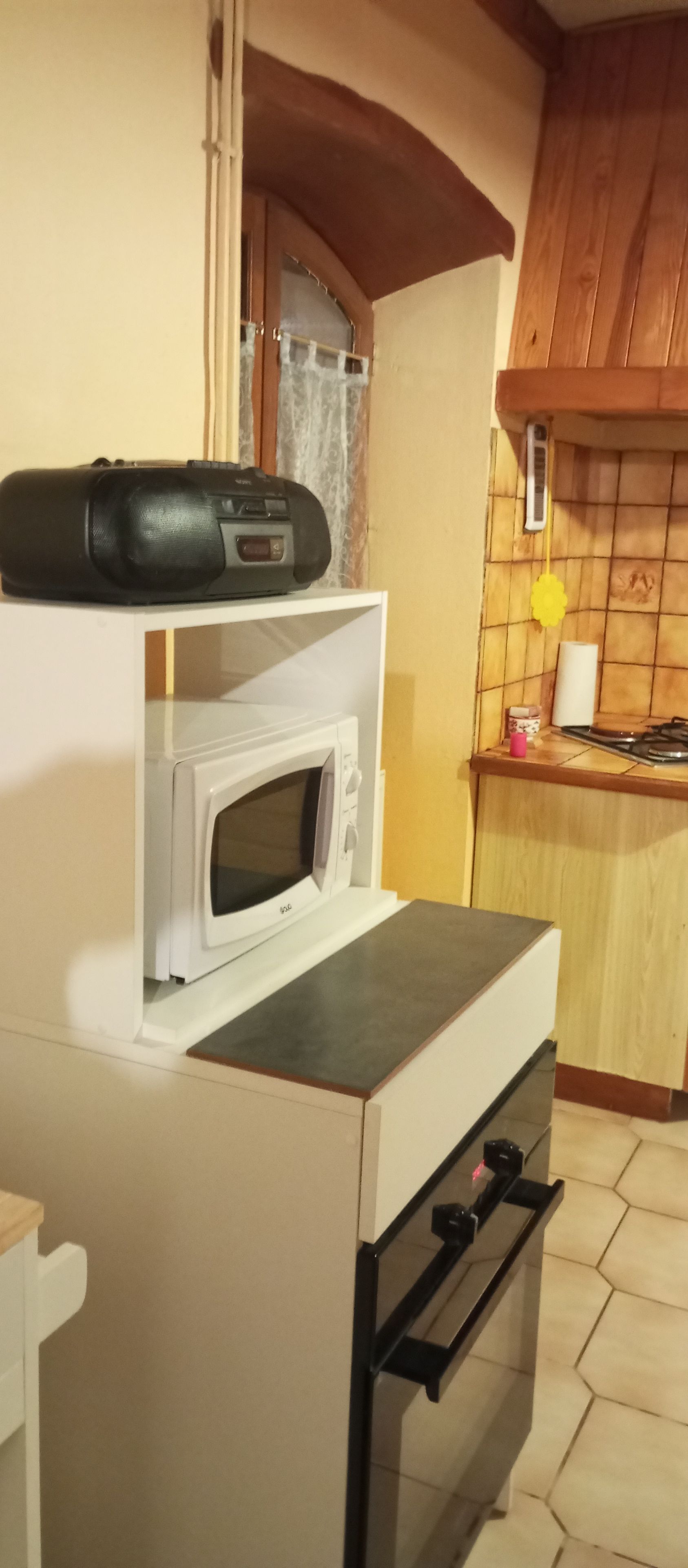 A compact kitchen with a microwave, oven, and a small countertop.