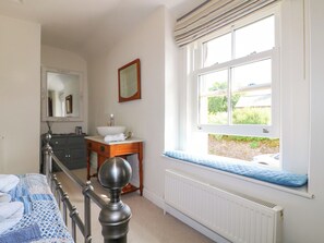 A bedroom with a bed, a dresser, a window with a view, and a radiator. - Sunnyside (Matlock)