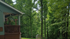 A building with a deck and a gravel path leading to a green area.