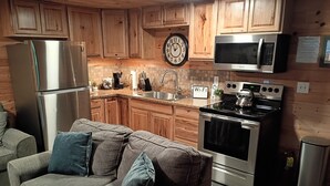 A kitchen with wooden cabinets, stainless steel appliances, a clock, and a Wi-Fi sign.