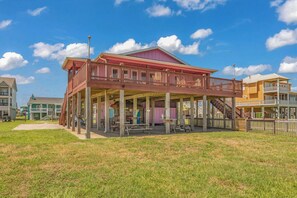 A two-story building with a covered porch and a balcony. - Crystal Beach Serenity Escape: 4BR Beachfront! Stunning Views & Outdoor Showers (Bolivar Peninsula)