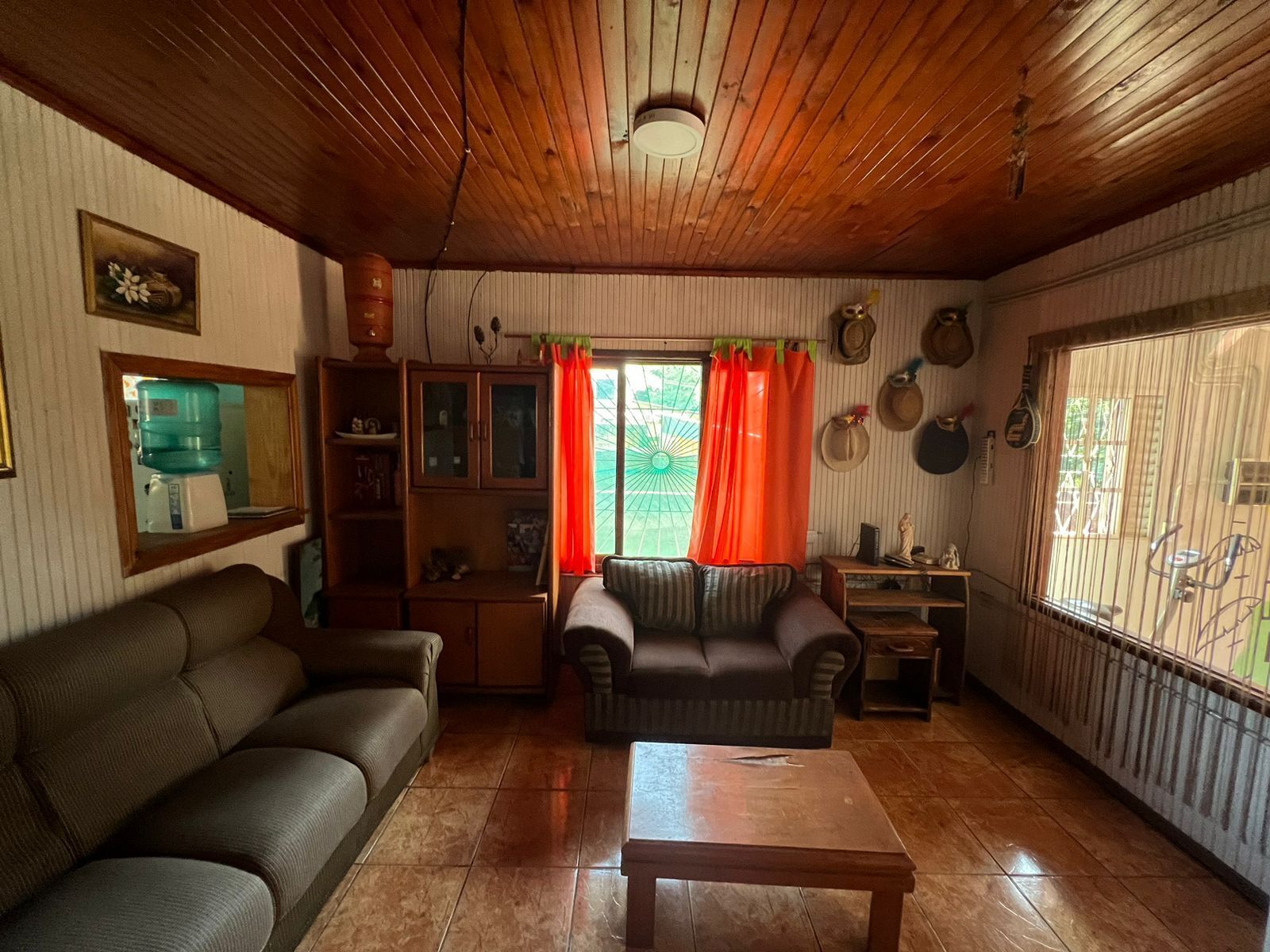 Una sala de estar con sofá, mesa de centro y ventana con cortinas.
