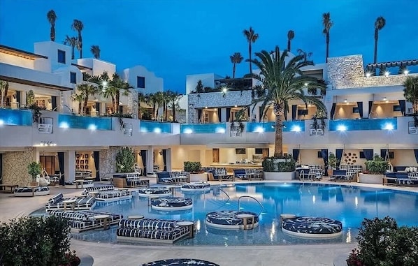 A hotel with multiple swimming pools, outdoor seating, and palm trees. - PALMS  1 BR MOUNTAIN VIEW W/ BALCONY (Las Vegas)